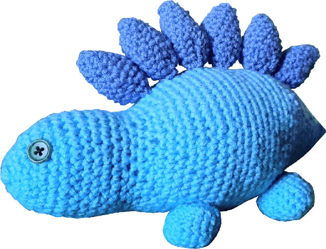 A light blue crocheted stegosaurus plushie with purple spikes and green button eyes.